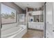 Bathroom showcasing soaking tub, shower, double sink vanity, and large window providing natural light at 10897 S Turtle Dove S Dr, Goodyear, AZ 85338