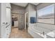 Bathroom featuring a soaking tub, closet with barn door, tile flooring and natural light at 10897 S Turtle Dove S Dr, Goodyear, AZ 85338