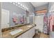 Bathroom featuring granite countertop, double sinks, vanity, and shower/tub at 10897 S Turtle Dove S Dr, Goodyear, AZ 85338