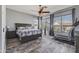 Cozy main bedroom features a ceiling fan, natural light and wood-look flooring at 10897 S Turtle Dove S Dr, Goodyear, AZ 85338