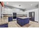 Spacious kitchen featuring granite countertops, stainless steel appliances and custom blue island at 10897 S Turtle Dove S Dr, Goodyear, AZ 85338