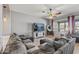 Comfortable living room with a large sectional sofa, a ceiling fan, and a flat-screen TV at 10897 S Turtle Dove S Dr, Goodyear, AZ 85338