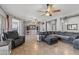 Open living space with tile flooring, a large sectional sofa, and ample seating at 10897 S Turtle Dove S Dr, Goodyear, AZ 85338
