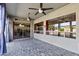 Enclosed outdoor living area with brick flooring, ceiling fans, and access to the kitchen at 10897 S Turtle Dove S Dr, Goodyear, AZ 85338