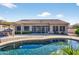 Inviting backyard pool features a baja shelf and lush landscaping to enhance outdoor enjoyment at 10897 S Turtle Dove S Dr, Goodyear, AZ 85338