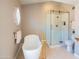 Elegant bathroom features a soaking tub, glass shower, and gold fixtures at 11025 N 10Th St, Phoenix, AZ 85020