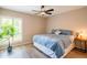 Cozy bedroom showcasing a ceiling fan, wood-look flooring, and a sunlit window with shutters at 11025 N 10Th St, Phoenix, AZ 85020