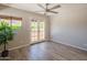 Bedroom with wood-look flooring, ceiling fan, and french doors leading to a balcony at 11025 N 10Th St, Phoenix, AZ 85020