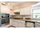 Bright kitchen features white cabinets, granite countertops, stainless steel appliances, and a garden view at 11025 N 10Th St, Phoenix, AZ 85020