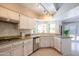 Bright kitchen features white cabinets, granite countertops, stainless steel appliances, tile floor, and garden views at 11025 N 10Th St, Phoenix, AZ 85020