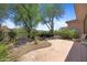 Lush backyard with beautiful desert landscaping, trees and a rock water feature at 11081 E Betony Dr, Scottsdale, AZ 85255