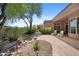 Beautiful backyard oasis featuring desert landscaping, a rock water feature, and shaded patio area with lounge chairs at 11081 E Betony Dr, Scottsdale, AZ 85255