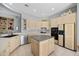 Charming kitchen featuring light-toned cabinets, black appliances, and a central island for food preparation at 11081 E Betony Dr, Scottsdale, AZ 85255