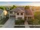 Aerial view showcases a well-maintained home with solar panels, a two-car garage, and lush green trees at 11866 N 143Rd Ave, Surprise, AZ 85379