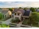 Aerial view of a two-story home with solar panels, manicured lawn, and a two car garage with mountain views at 11866 N 143Rd Ave, Surprise, AZ 85379