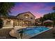 Inviting backyard pool and covered patio create an outdoor oasis for relaxation and entertaining under a colorful sky at 11866 N 143Rd Ave, Surprise, AZ 85379