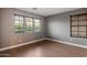Minimalist bedroom with hardwood floors, gray paint, and a window bringing in natural light at 11866 N 143Rd Ave, Surprise, AZ 85379