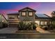 Charming two-story home with solar panels, lush landscaping, and a well-manicured front yard at twilight at 11866 N 143Rd Ave, Surprise, AZ 85379