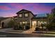 Charming two-story home with solar panels, lush landscaping, and a well-manicured front yard at twilight at 11866 N 143Rd Ave, Surprise, AZ 85379