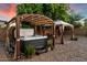 Backyard with a hot tub, two gazebos, string lights, and lush greenery at 11866 N 143Rd Ave, Surprise, AZ 85379