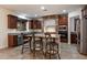 Inviting kitchen featuring a stone archway, dark wood cabinets, and a central island at 11866 N 143Rd Ave, Surprise, AZ 85379
