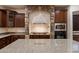 Spacious kitchen features a stone arch over the stovetop and a large island with granite countertops at 11866 N 143Rd Ave, Surprise, AZ 85379