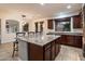Kitchen island with granite countertop and pendant lights, plus sink, cabinets, and view to the backyard at 11866 N 143Rd Ave, Surprise, AZ 85379