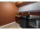 Modern laundry room with appliances and a shelf for storing cleaning supplies at 11866 N 143Rd Ave, Surprise, AZ 85379