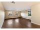 Bright living room with three windows and hardwood flooring; neutral colors fill the room at 11866 N 143Rd Ave, Surprise, AZ 85379