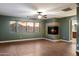Living room with hardwood flooring, fireplace, ceiling fan, and window view to the backyard at 11866 N 143Rd Ave, Surprise, AZ 85379