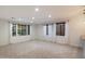 Bright, open living room with neutral carpet, large windows, and sheer white curtains at 11866 N 143Rd Ave, Surprise, AZ 85379