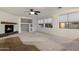 Spacious living room featuring carpet, tile, fireplace, ceiling fan, and natural light from the backyard at 11866 N 143Rd Ave, Surprise, AZ 85379