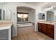 Primary bathroom with dual sinks, soaking tub under window, and separate mirrors at 11866 N 143Rd Ave, Surprise, AZ 85379