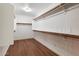 A spacious walk-in closet features wood flooring and ample shelving space for storage at 11866 N 143Rd Ave, Surprise, AZ 85379