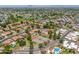 Wide aerial shot displays a residential community with green spaces, tennis courts, pools, and tree-lined streets at 1338 E Greenway Cir, Mesa, AZ 85203