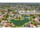 Bird's eye view featuring a community with tennis courts, pool, serene lake, and well-maintained residences at 1338 E Greenway Cir, Mesa, AZ 85203