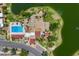 Overhead view of a community pool and pool-side seating nestled within a tranquil lake and green surroundings at 1338 E Greenway Cir, Mesa, AZ 85203