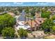 Stunning aerial view of property showcasing landscaped yard, complemented by charming neighborhood and palm tree lined street at 1338 E Greenway Cir, Mesa, AZ 85203