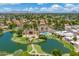 Expansive aerial view featuring a serene community lake and pool, surrounded by lush greenery and residences at 1338 E Greenway Cir, Mesa, AZ 85203