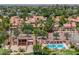 Expansive aerial view featuring tennis courts and community pool amidst lush greenery and residential homes at 1338 E Greenway Cir, Mesa, AZ 85203