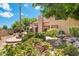 Lush backyard with a fountain, fire pit, and mature landscaping, perfect for relaxing and entertaining at 1338 E Greenway Cir, Mesa, AZ 85203