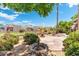 Backyard oasis featuring a decorative fountain, fire pit, mature landscaping, and community views at 1338 E Greenway Cir, Mesa, AZ 85203