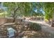 Secluded backyard featuring a stone bench, mature trees, and a glimpse of the sun room at 1338 E Greenway Cir, Mesa, AZ 85203