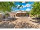 Expansive backyard featuring a spacious patio and views of desert landscaping and mature trees at 1338 E Greenway Cir, Mesa, AZ 85203