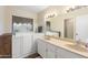 Well-lit bathroom with double sink vanity, walk-in tub, and neutral color palette at 1338 E Greenway Cir, Mesa, AZ 85203