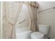 Cozy bathroom featuring a shower-tub combination, toilet, and patterned shower curtain at 1338 E Greenway Cir, Mesa, AZ 85203