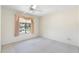 Light-filled bedroom with neutral carpet, ceiling fan, and large window offering outdoor views at 1338 E Greenway Cir, Mesa, AZ 85203
