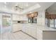 Clean kitchen featuring white cabinetry, tile countertops, and floral window treatments at 1338 E Greenway Cir, Mesa, AZ 85203