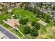 Aerial view of a park with a playground, volleyball court, basketball court, and grassy areas at 1338 E Greenway Cir, Mesa, AZ 85203