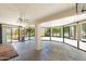 Spacious sun room with flagstone flooring, large windows, and a traditional grandfather clock at 1338 E Greenway Cir, Mesa, AZ 85203